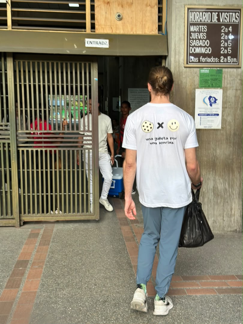 Voluntario de ENLACE con la franela 'una galleta por una sonrisa' entrando a un hospital
